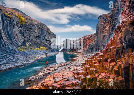 Touristenwanderung auf dem Grund des Canyons mit Basaltsäulen. Unglaubliche Sommerszene im Studlagil Canyon. Malerischer Blick am Morgen auf Island, Europa Stockfoto