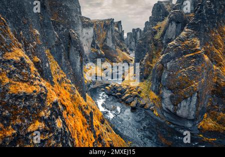 Landschaftsfotografie aus der Luft. Blick von der fliegenden Drohne auf Fjadrargljufur Canyon und Fluss. Dramatische Herbstszene im Südosten Islands, Europa. Travelin Stockfoto