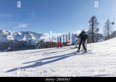 Eine Gruppe von Skifahrern auf der Piste mit Blick auf Passo Groste. Skigebiet im Dolomiten-Blick auf Passo Groste - Skipisten von Madonna di Campiglio. Alpin Stockfoto