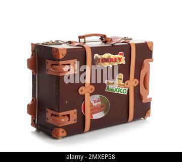 Retro-Koffer mit Reiseaufklebern auf weißem Hintergrund Stockfoto