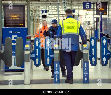 Ticketabholer des Kundendienstbetreibers an der Barriere am Hauptbahnhof Glasgow, Schottland, Großbritannien Stockfoto