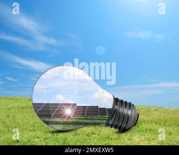 Alternative Energiequelle. Glühlampe mit Solarmodulen im Freien Stockfoto