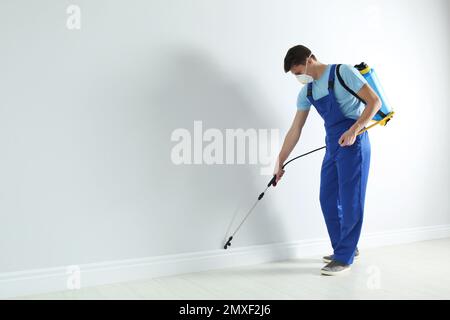 Schädlingsbekämpfungsarbeiter, die Pestizide im Zimmer versprühen. Platz für Text Stockfoto