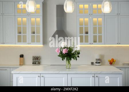 Pinkfarbene Blumenstrauß auf weißem Marmortisch im Küchenbereich Stockfoto
