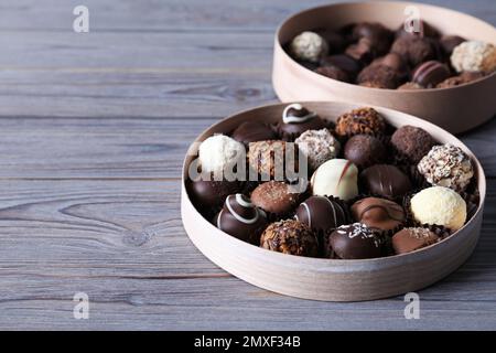 Schachteln mit leckeren Schokoladenbonbons auf einem Holztisch Stockfoto