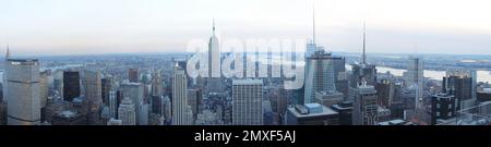 Winterdämmerung in NYC: Ein atemberaubendes Panoramafoto fängt die berühmte Skyline der Stadt ein, die von Abendlichtern, kaltem Wetter und Wolkenschnuppen getaucht ist Stockfoto