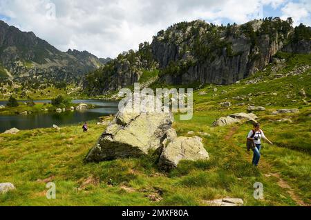 Wanderer am Estanh Plan See im Aigüestortes i Estany de Sant Maurici Nationalpark (Aran-Tal, Lleida, Pyrenäen, Cataluña, Spanien) Stockfoto