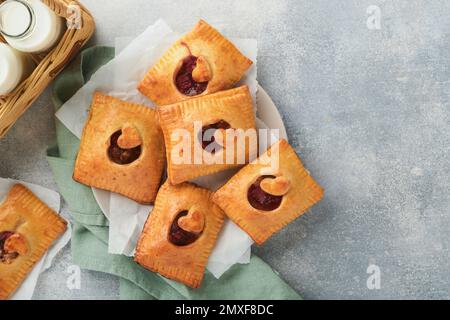 Valentinstag herzförmige Handkuchen. Mini-Blätterteig oder Handkuchen gefüllt mit Apfel und streuen Sie Zuckerpulver auf den Teller. Eine Idee für hausgemachte Romantiker Stockfoto