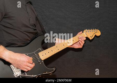 Vaduz, Liechtenstein, 23. Dezember 2022 Künstler tritt mit schwarzer Fender Stratocaster-Elektrogitarre auf Stockfoto