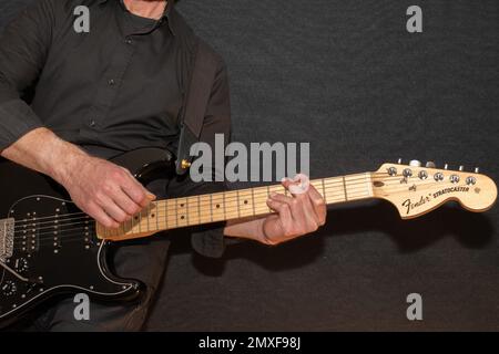 Vaduz, Liechtenstein, 23. Dezember 2022 Künstler tritt mit schwarzer Fender Stratocaster-Elektrogitarre auf Stockfoto