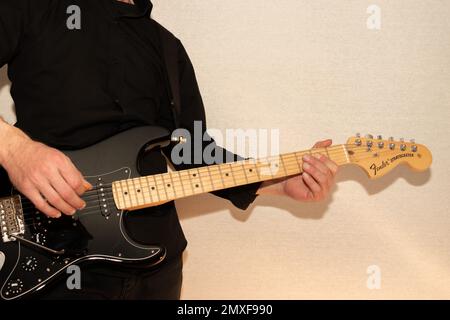 Vaduz, Liechtenstein, 23. Dezember 2022 Künstler tritt mit schwarzer Fender Stratocaster-Elektrogitarre auf Stockfoto