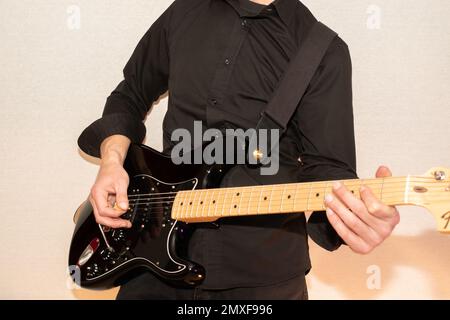 Vaduz, Liechtenstein, 23. Dezember 2022 Künstler tritt mit schwarzer Fender Stratocaster-Elektrogitarre auf Stockfoto