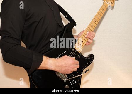 Vaduz, Liechtenstein, 23. Dezember 2022 Künstler tritt mit schwarzer Fender Stratocaster-Elektrogitarre auf Stockfoto