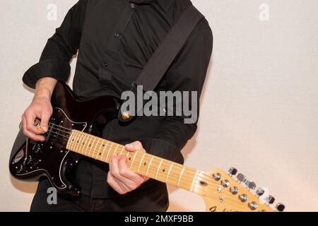 Vaduz, Liechtenstein, 23. Dezember 2022 Künstler tritt mit schwarzer Fender Stratocaster-Elektrogitarre auf Stockfoto