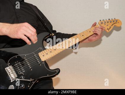 Vaduz, Liechtenstein, 23. Dezember 2022 Künstler tritt mit schwarzer Fender Stratocaster-Elektrogitarre auf Stockfoto