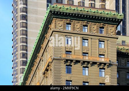 Eine eindrucksvolle Gegenüberstellung von historischer und moderner Architektur mit einer kunstvollen Fassade mit einem grünen Dach und zeitgenössischen Wolkenkratzern. Stockfoto