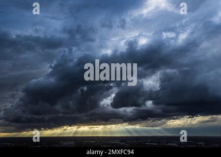 Sonnenstrahlen durchdringen dunkle, unheilvolle Wolken über der Innenstadt von Atlanta. Stockfoto