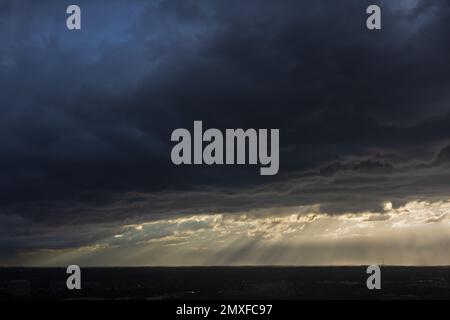 Hoffnungsvolle Sonnenstrahlen durchdringen dunkle, bedrohliche Sturmwolken über Midtown Atlanta Stockfoto