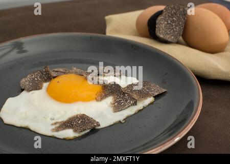 Gebratene Trüffeleier mit einer Knollenmelanosporum-Wintertruffel Stockfoto