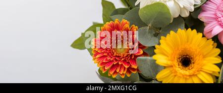 Gerber Daisy sitzt einen schönen Korb auf dem lokalen Bauernmarkt. Bouquet mit sanften gelben, roten, orangefarbenen Gänseblümchen und rosa Blumen. Feier Stockfoto