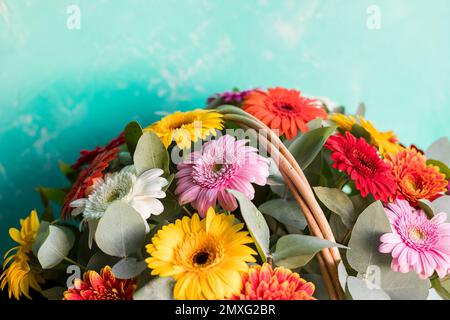 Gerber Daisy sitzt einen schönen Korb auf dem lokalen Bauernmarkt. Bouquet mit sanften gelben, roten, orangefarbenen Gänseblümchen und rosa Blumen. Feier Stockfoto