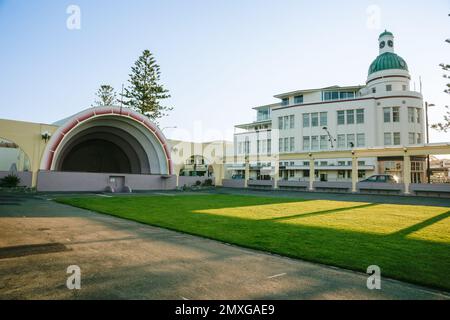 Napier Neuseeland 5 2010. Oktober; redaktionelle Abendschatten auf dem Rasen durch eine Schallschale mit Gebäudehintergrund im Deco-Stil. Stockfoto