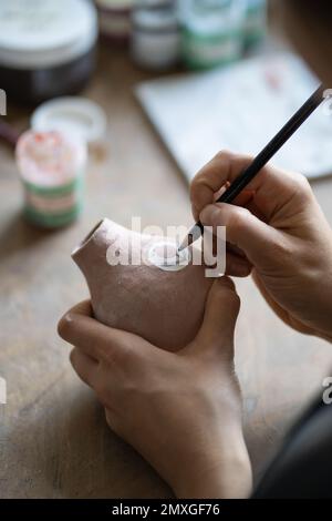 Craftsmaster macht interessante Skizzenzeichnung Symbol auf Krug mit Bleistift für die Erstellung von Entwurf Stockfoto