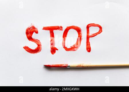 Aufschrift STOP in roter Farbe auf weißem Hintergrund Stockfoto