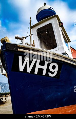 Trockendock-Fischerboot am West Bay Kai, Dorset. Farbenfroh. Stockfoto