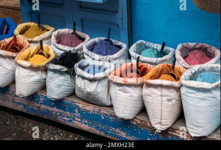 Trockene Farbe für Kreativität in offenen Beuteln mit leuchtenden Pigmenten in verschiedenen Farben wird auf dem Straßenmarkt verkauft. Straßenladen auf dem Markt in Chefchaouen Stockfoto