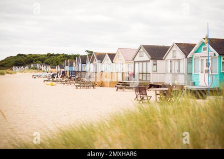 Eine Reihe hölzerner Strandhütten zwischen Sanddünen. Hengistbury Head, Dorset, Großbritannien Stockfoto