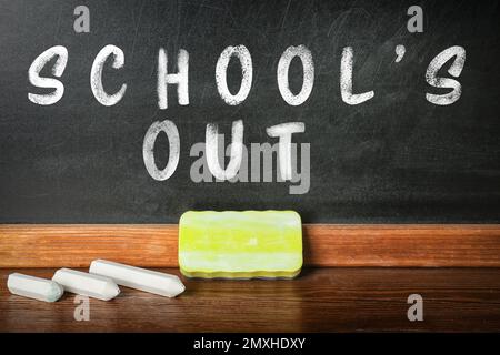 Weiße Kreide und Staubwedel liegen auf dem Tisch neben der Tafel, die SMS-SCHULE IST AUS Stockfoto