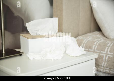 Benutzte Papiertücher und Halter auf dem Tisch im Schlafzimmer Stockfoto