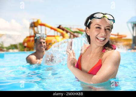 Glückliches Paar, das Spaß im Swimmingpool hat. Sommerferien Stockfoto