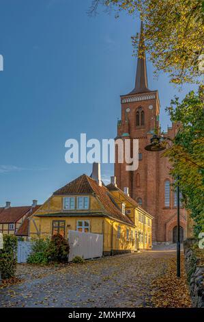 roskilde Kathedrale und ein gelbes Herbsthaus, Roskilde, Dänemark, 23. Oktober 2022 Stockfoto