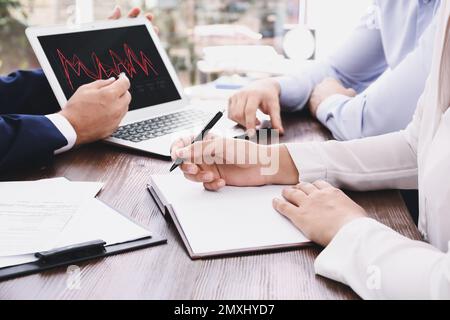 Makler, die an einem Tisch im Büro arbeiten, schließen. Devisenhandel Stockfoto