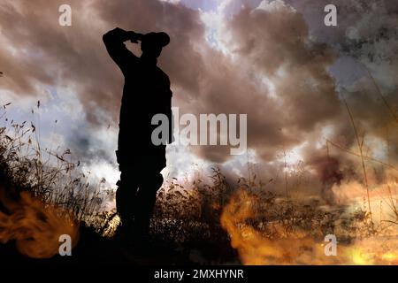 Silhouette des Soldatensaluments auf dem Schlachtfeld. Militärdienst Stockfoto
