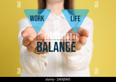 Frau, die Beruf und Privatleben auf gelbem Hintergrund ausdrückt, Nahaufnahme Stockfoto