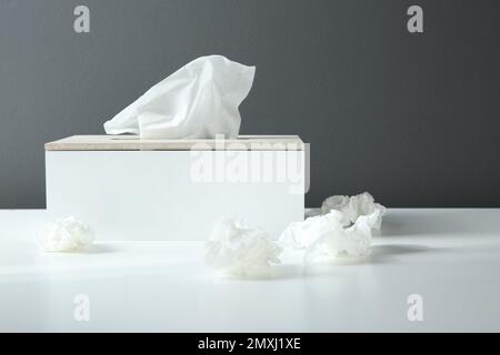 Gebrauchte Papiertücher und Halter auf weißem Tisch Stockfoto