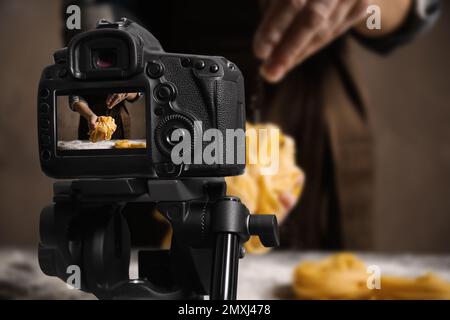 Lebensmittelfotografie. Schießen auf eine Frau, die Pasta macht, konzentrieren Sie sich auf die Kamera Stockfoto