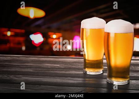 Frisches kaltes Bier auf Holztisch im Pub, Platz für Text Stockfoto