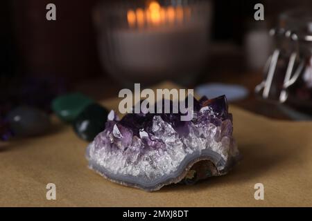 Komposition mit heilendem Amethyst-Edelstein auf dem Tisch, Nahaufnahme Stockfoto