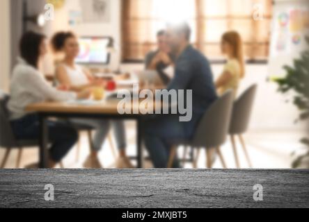 Leere Steinoberfläche und unscharfe Sicht auf professionelle Innenarchitekten, die im Büro arbeiten, Nahaufnahme. Platz für Text Stockfoto