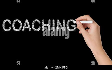 Business- oder Life-Trainer schreibt Wortwahl Coaching an die Tafel, Nahaufnahme Stockfoto