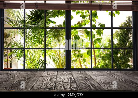 Holztisch und -Fenster mit Jalousien im Hintergrund Stockfoto