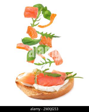 Leckeres Bruschetta mit fliegenden Zutaten auf weißem Hintergrund Stockfoto