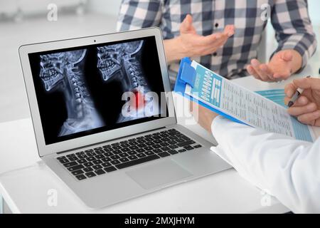 Arzt-Berater in der Klinik, Nahaufnahme. Fokus auf Laptop-Anzeige von Röntgenaufnahmen von Krebspatienten Stockfoto