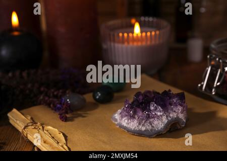 Komposition mit heilendem Amethyst-Edelstein auf dem Tisch Stockfoto