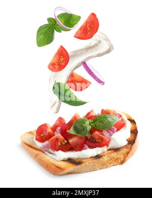 Leckeres Bruschetta mit fliegenden Zutaten auf weißem Hintergrund Stockfoto