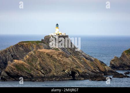 Der Fidra Lighthouse auf einer Klippe im Vereinigten Königreich mit dem Meer und dem Horizont im Hintergrund Stockfoto